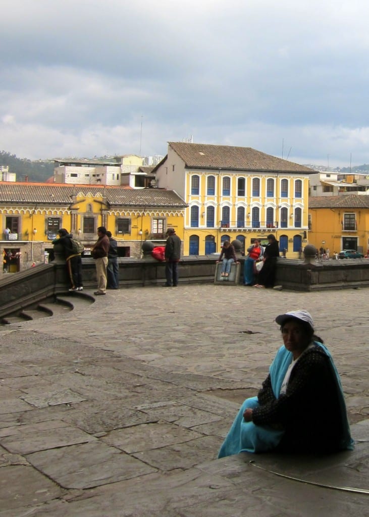 A woman sits on the steps of Quito's St. Francis in the late afternoon